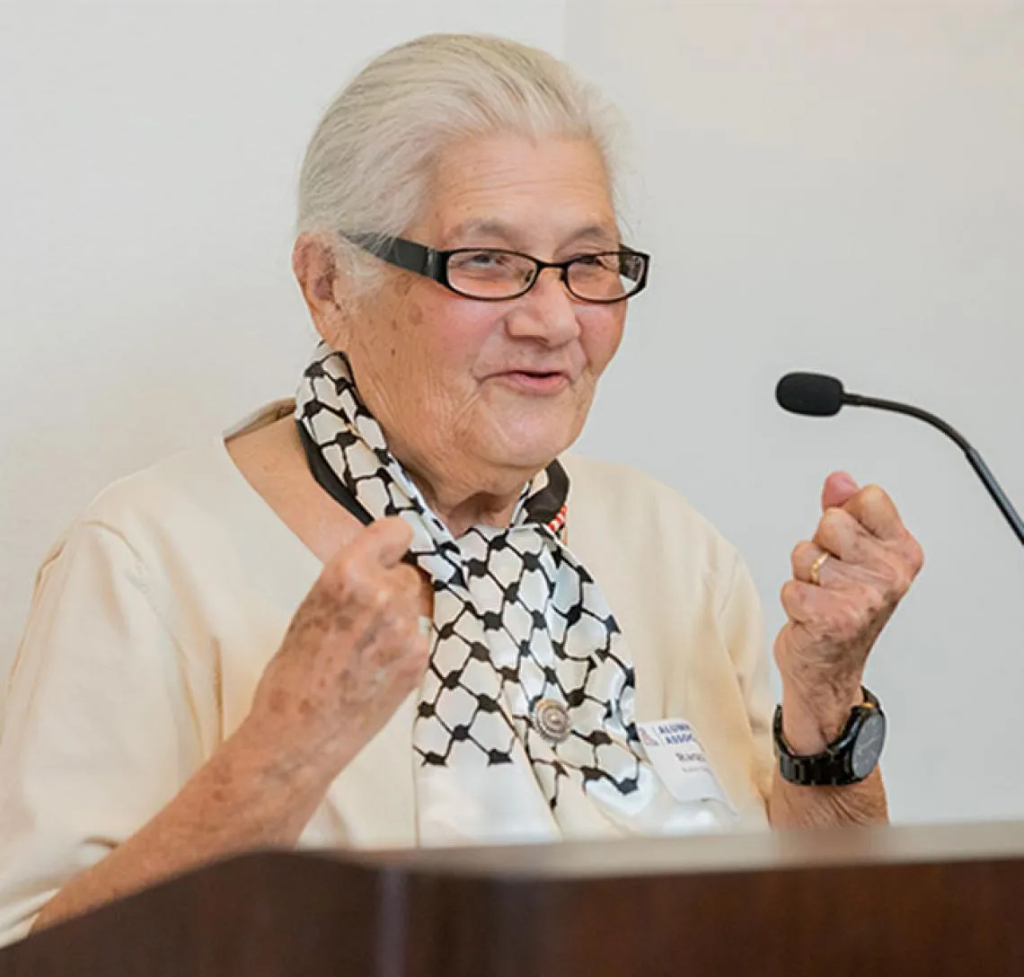 Photo of a member of the Hispanic Alumni Club's founding group as she speaks to an audience from a podium