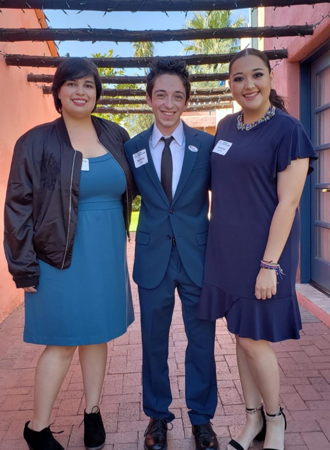 Three students pose for a photo, Nathan, is centered and flanked by two female students, all are smiling and facing the camera